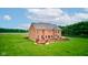 Backyard aerial of a brick home with a deck and a large, well-maintained green lawn at 8371 N 400 W, Fairland, IN 46126