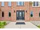 Inviting entrance to brick home with dark front door with glass, flanking lamps, and manicured shrubbery at 8371 N 400 W, Fairland, IN 46126