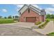 Two-story brick home featuring a two-car garage with a wooden door, a large concrete driveway, and professionally landscaped flower beds at 8371 N 400 W, Fairland, IN 46126