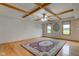 Bright living room with a decorative rug, wooden floors, two windows, and a decorative wood-beamed ceiling at 8371 N 400 W, Fairland, IN 46126