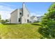 The well-manicured backyard showcases a two-story home and a trampoline at 9125 Timpani Way, Indianapolis, IN 46231