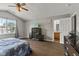 Bright main bedroom with a ceiling fan, wood-look floors, a television and ensuite access at 9125 Timpani Way, Indianapolis, IN 46231