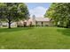Expansive backyard with lush green lawn, mature trees, and a cozy deck, ideal for outdoor enjoyment at 9363 Hadway Dr, Indianapolis, IN 46256