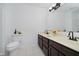 Bathroom featuring a double sink vanity with dark cabinets, a toilet, and a large mirror at 9363 Hadway Dr, Indianapolis, IN 46256