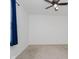 Empty carpeted bedroom featuring a ceiling fan and blue curtains hanging near the window at 9363 Hadway Dr, Indianapolis, IN 46256