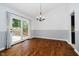 Bright dining room with hardwood floors, stylish chandelier, and sliding door access to outdoor deck at 9363 Hadway Dr, Indianapolis, IN 46256