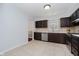Practical kitchen design with tile floors, dark cabinetry, and a view into the adjacent living space at 9363 Hadway Dr, Indianapolis, IN 46256
