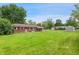 Expansive backyard with lush green grass and a brick house, perfect for outdoor activities at 9458 Dawn Dr, Brownsburg, IN 46112