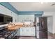 This stylish kitchen features stainless steel appliances, modern two-tone cabinetry, and wood grain flooring at 9458 Dawn Dr, Brownsburg, IN 46112