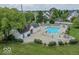 Community pool surrounded by lounge chairs, manicured shrubs, and shade umbrellas at 9664 Legare St # 2601, Fishers, IN 46038