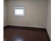 Neutral bedroom features hardwood floors, neutral walls, and one window providing natural light at 1033 Cottage Ave, Columbus, IN 47201