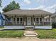 Charming single-story home featuring a cozy front porch with wood railings and a well-maintained lawn at 1033 Cottage Ave, Columbus, IN 47201
