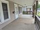 Spacious covered front porch with wood railings, a white door with glass, and space for seating at 1033 Cottage Ave, Columbus, IN 47201