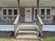 Inviting front porch with wood railings, steps, and white door, perfect for relaxing outdoors at 1033 Cottage Ave, Columbus, IN 47201