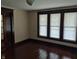 Sunlit living room featuring hardwood floors, wood trim, and three large windows at 1033 Cottage Ave, Columbus, IN 47201