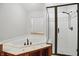 Bathroom featuring a glass shower, a large jacuzzi and a window providing natural light at 10410 Trillium Ct, Noblesville, IN 46060