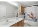 Bathroom with double sink, toilet, and a shower with a whimsical dinosaur-themed curtain at 10410 Trillium Ct, Noblesville, IN 46060