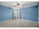 Spacious bedroom with blue walls, carpet flooring, and a ceiling fan at 10410 Trillium Ct, Noblesville, IN 46060