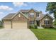 Charming brick two-story home with a three-car garage and well-manicured lawn and shrubbery at 10410 Trillium Ct, Noblesville, IN 46060
