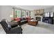 Inviting living room features a stone fireplace, a comfortable leather sofa, and plenty of light at 10410 Trillium Ct, Noblesville, IN 46060