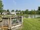 This backyard features a wood deck with serene views of the adjacent pond and lush greenery at 10832 Tealpoint Dr, Indianapolis, IN 46229