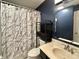 Cozy bathroom with tub, commode, vanity, decorative shelving, and marbled shower curtain at 10832 Tealpoint Dr, Indianapolis, IN 46229