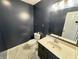 Powder room featuring dark blue walls, a tile floor, and a white porcelain toilet at 10832 Tealpoint Dr, Indianapolis, IN 46229