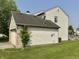 View of the home's attached garage, showing the brick facade, siding, and well-maintained lawn at 10832 Tealpoint Dr, Indianapolis, IN 46229