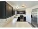 Well-lit kitchen featuring black cabinets, stainless steel appliances, and neutral countertops at 10832 Tealpoint Dr, Indianapolis, IN 46229