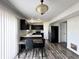 Well-lit kitchen featuring black cabinets, stainless steel appliances, and wood grain flooring at 10832 Tealpoint Dr, Indianapolis, IN 46229