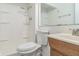 A clean bathroom with a shower, toilet, wood vanity and built-in shelving at 11114 Wismar Dr, Indianapolis, IN 46235