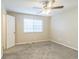 Neutral bedroom with a ceiling fan, plush carpet, and a window letting in natural light at 11114 Wismar Dr, Indianapolis, IN 46235