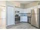 A bright kitchen featuring white cabinets, stainless steel appliances, and modern gray flooring at 11114 Wismar Dr, Indianapolis, IN 46235