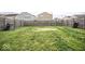 Backyard with grass area, surrounded by a wooden fence and neighboring houses at 11303 Cuyahoga Dr, Indianapolis, IN 46235