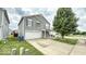 Two-story home with gray siding, white garage door, and well-maintained front lawn at 11303 Cuyahoga Dr, Indianapolis, IN 46235