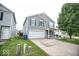 Two-story home featuring gray siding, a two-car garage, and a tidy front yard at 11303 Cuyahoga Dr, Indianapolis, IN 46235