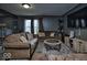 Cozy living room with gray walls, a plush sofa, and a large television at 11303 Cuyahoga Dr, Indianapolis, IN 46235
