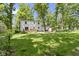 Expansive backyard with lush green lawn, mature trees, home, and wooden sauna at 11461 N College Ave, Carmel, IN 46032