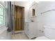 Bright bathroom featuring a white vanity, marble tile, and walk-in shower with glass door at 11461 N College Ave, Carmel, IN 46032
