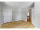 Neutral bedroom featuring hardwood floors, closet and an open doorway to an adjacent hall at 11461 N College Ave, Carmel, IN 46032
