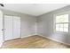This bedroom has wood floors, a large window, and a closet with sliding doors at 11461 N College Ave, Carmel, IN 46032