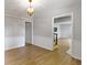 Elegant dining room featuring hardwood floors, a chandelier, and wainscoting open to other living spaces at 11461 N College Ave, Carmel, IN 46032