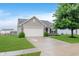 Charming home featuring a two-car garage, well-maintained lawn, and mature tree, enhancing curb appeal at 11521 Short Iron Ln, Indianapolis, IN 46235