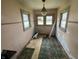 A small dining area with two windows, showcasing the room's potential, although the floor needs repair at 1201 N Canal St, Alexandria, IN 46001