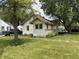 Cozy home showcasing light yellow siding and a lush green lawn at 1201 N Canal St, Alexandria, IN 46001