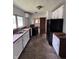 Kitchen with white cabinets, wood countertop, black fridge, and window at 1201 N Canal St, Alexandria, IN 46001