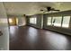 Spacious vacant living room featuring hardwood floors, multiple windows and ceiling fans at 1201 N Canal St, Alexandria, IN 46001