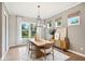 Inviting dining room with modern light fixture, neutral decor, and large windows overlooking backyard at 12594 Pasco St, Fishers, IN 46038