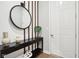 Entryway featuring hardwood flooring, a round mirror, modern light fixture, and a console table at 12594 Pasco St, Fishers, IN 46038