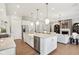 Modern kitchen featuring stainless steel appliances, center island, and seamless flow to living area at 12594 Pasco St, Fishers, IN 46038